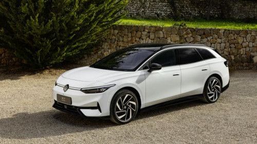 Voor een muur van stenen staat een witte Volkswagen ID.7 Tourer