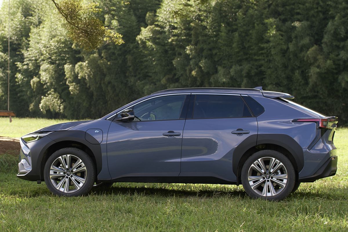 Zijaanzicht van de Subaru Solterra die geparkeerd staat op gras