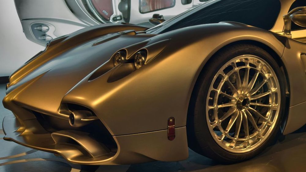 Een zilveren sportwagen staat geparkeerd in een garage