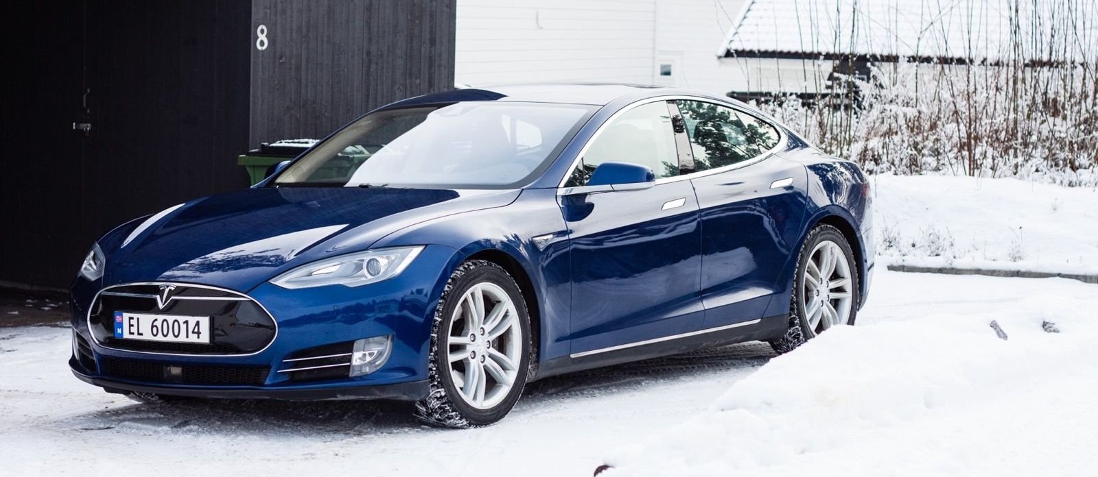 Een blauw Tesla Model S staat geparkeerd in de sneeuw