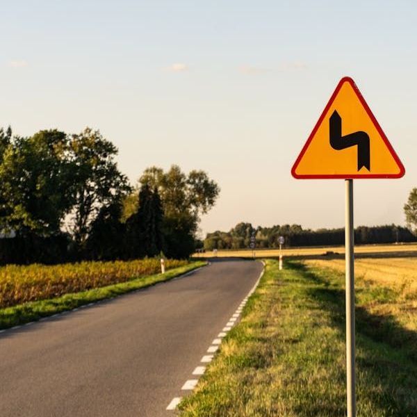 Een verkeersbord waarschuwt voor bochten in de weg