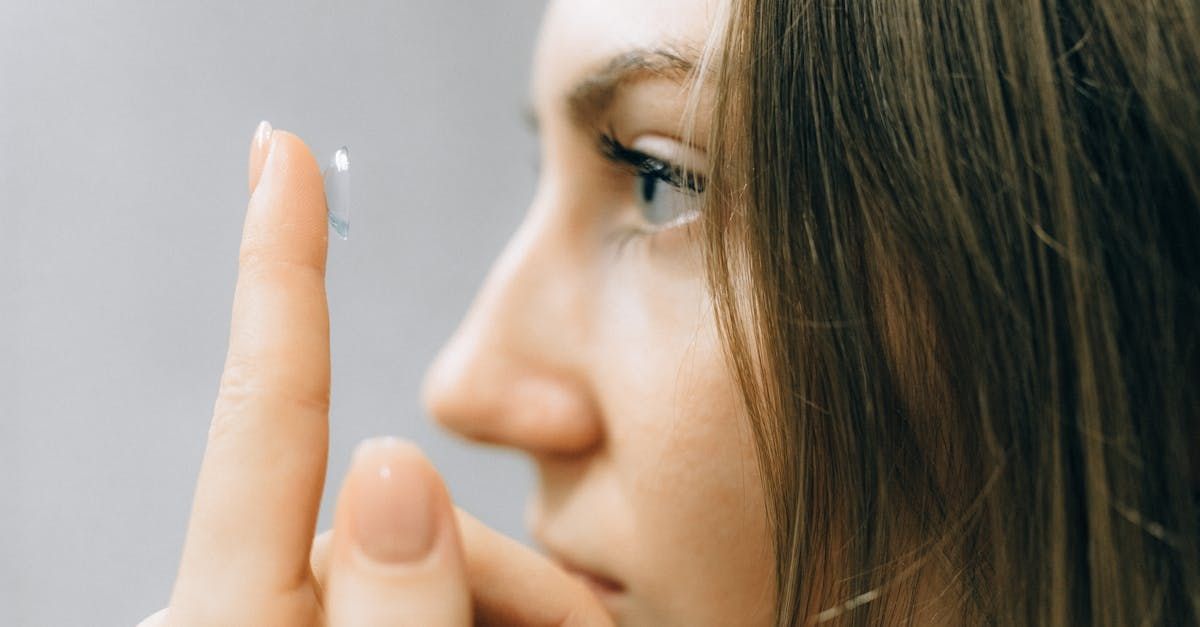 side view of woman putting on contact lenses