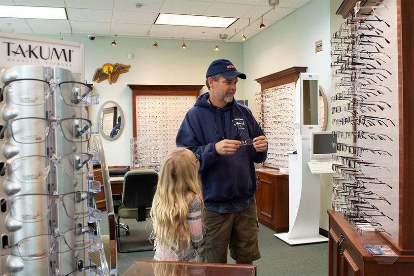 A man and his daughter are shopping for eyeglasses