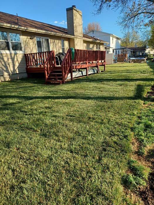 A house with a red deck and stairs in the backyard.