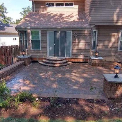 A house with a patio in front of it and a sliding glass door.