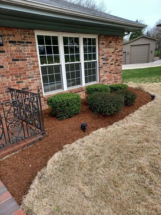 A brick house with a garden in front of it.