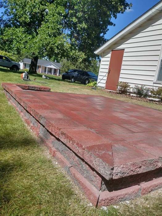 A concrete slab is sitting in the grass in front of a house.