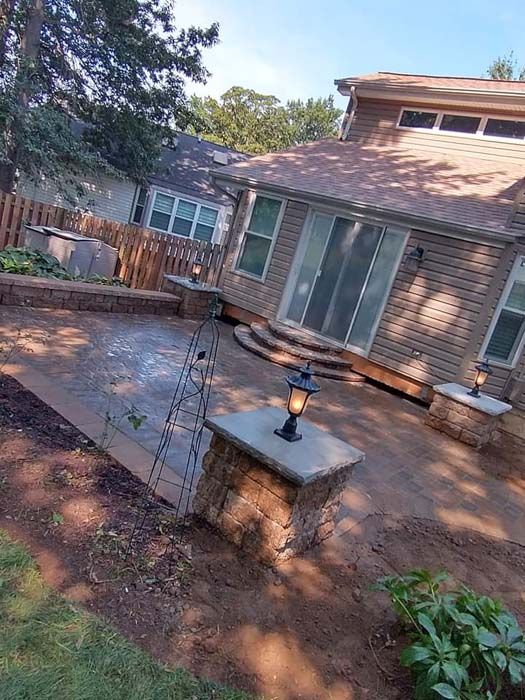 A house with a patio and a lantern in front of it.