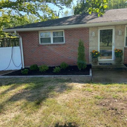 A brick house with a garden in front of it.