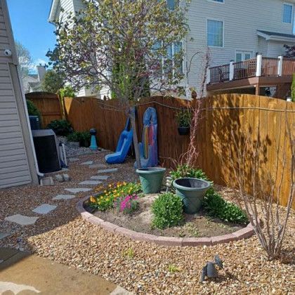 A backyard with a wooden fence and a slide.