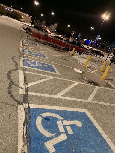 A handicapped parking spot in a parking lot at night.