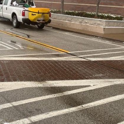 A white truck with a yellow trailer is parked in a parking lot.