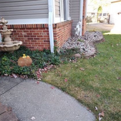 A brick house with a fountain and a pumpkin in front of it.