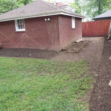 A brick house with a wooden fence in the backyard.