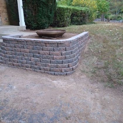 A brick wall with a bowl on top of it in front of a house.