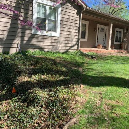 A house with a porch and a lot of grass in front of it.