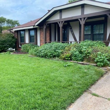 A house with a lush green lawn in front of it