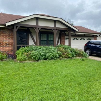 A brick house with a car parked in front of it.
