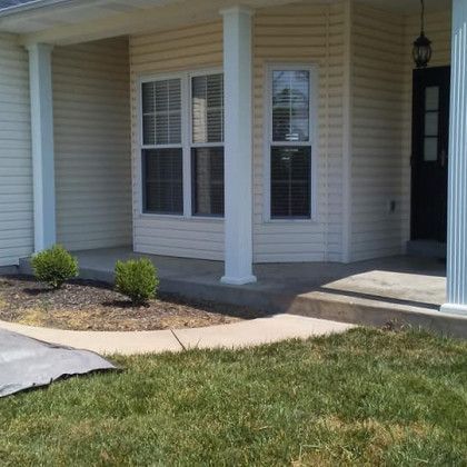 A white house with a porch and a black door