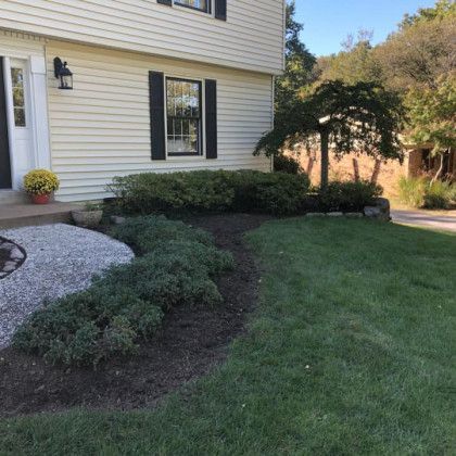 A large white house with a lush green lawn in front of it.
