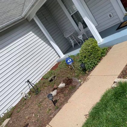 A house with a porch and a walkway leading to it.