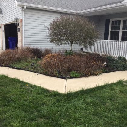 A house with a sidewalk in front of it and a garden in front of it.