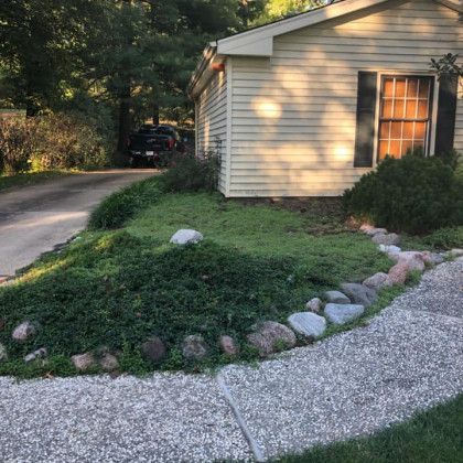 A house with a driveway and a sidewalk in front of it.