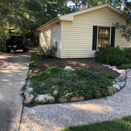 A truck is parked in front of a small white house.