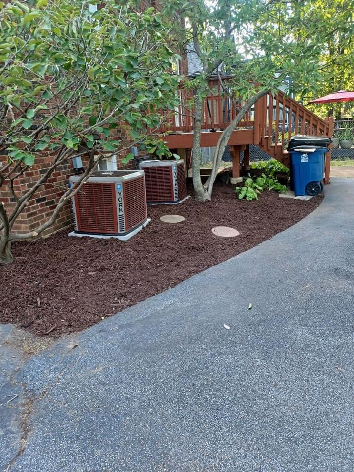 There are two air conditioners in the backyard of a house.