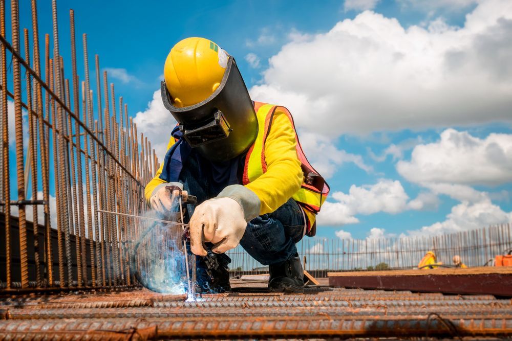 A Construction Worker Is Welding A Metal Structure On A Construction Site — Tinman's Welding Worx In Sarina, QLD