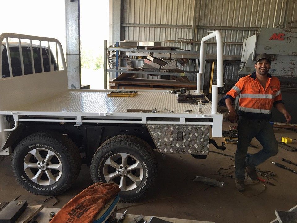 A Man Is Standing Next To A Trailer In A Garage — Tinman's Welding Worx In Nebo, QLD