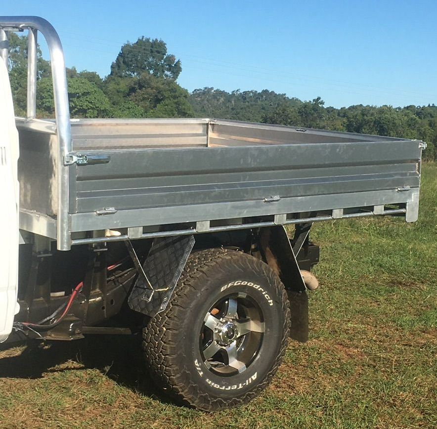 A Truck With A Tire Is Parked In A Grassy Field — Tinman's Welding Worx In Sarina, QLD