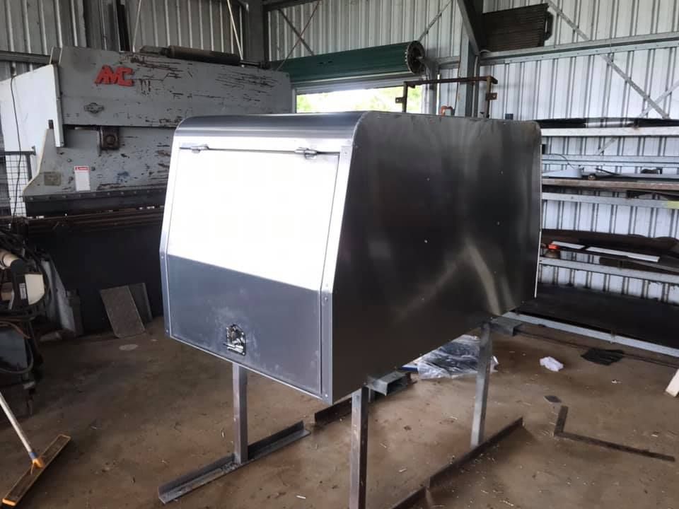 A Stainless Steel Canopy Is Sitting In A Garage Next To A Machine — Tinman's Welding Worx In Sarina, QLD