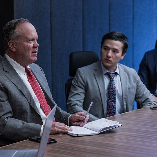 Two men in suits and ties are sitting at a table