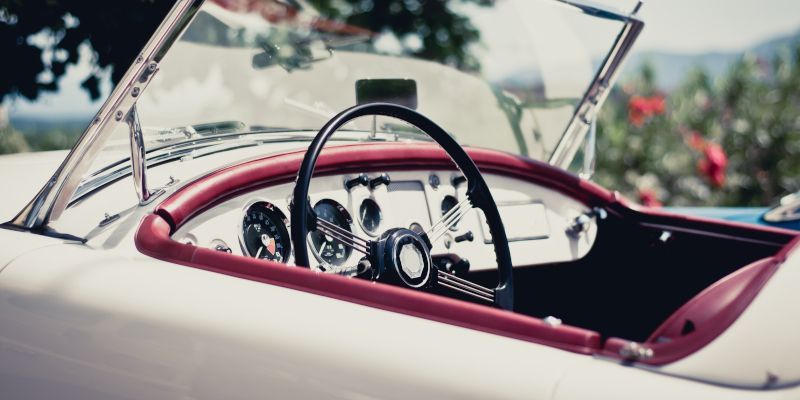 A close up of a car 's steering wheel and dashboard.