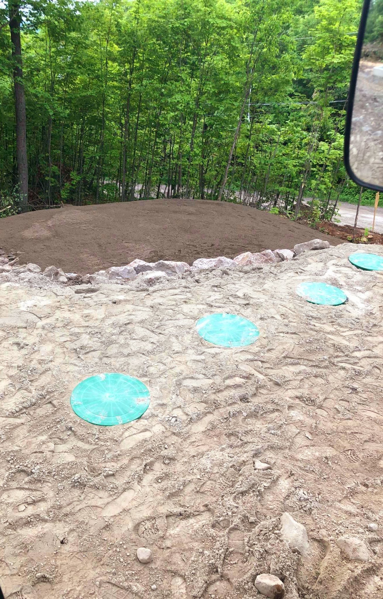 Un camion roule sur un chemin de terre avec des arbres en arrière-plan.