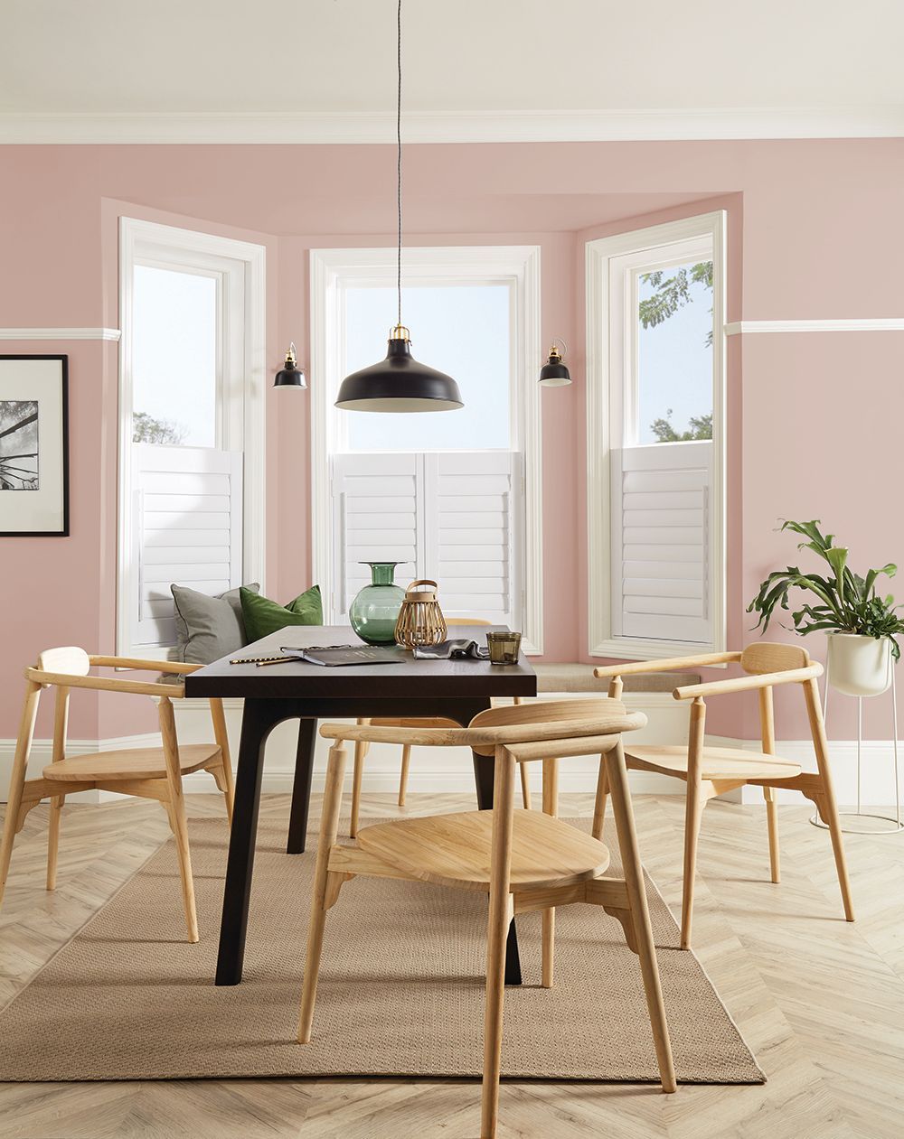 A dining room with pink walls and a table and chairs
