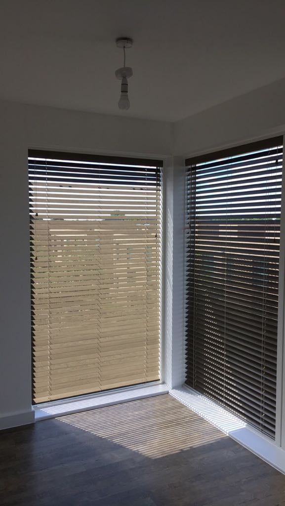 A room with a large window and blinds on it.