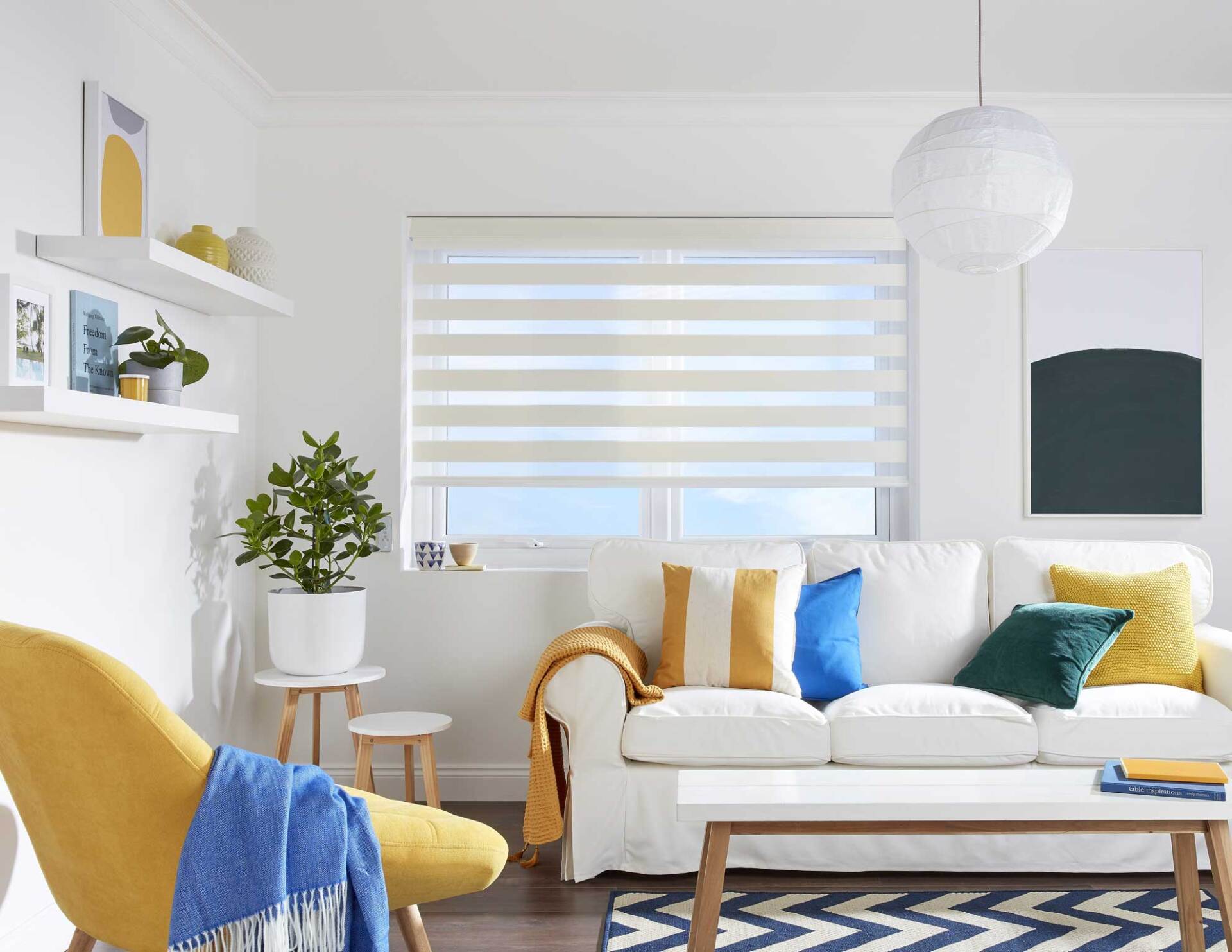 A living room with a couch , chair , table and window.