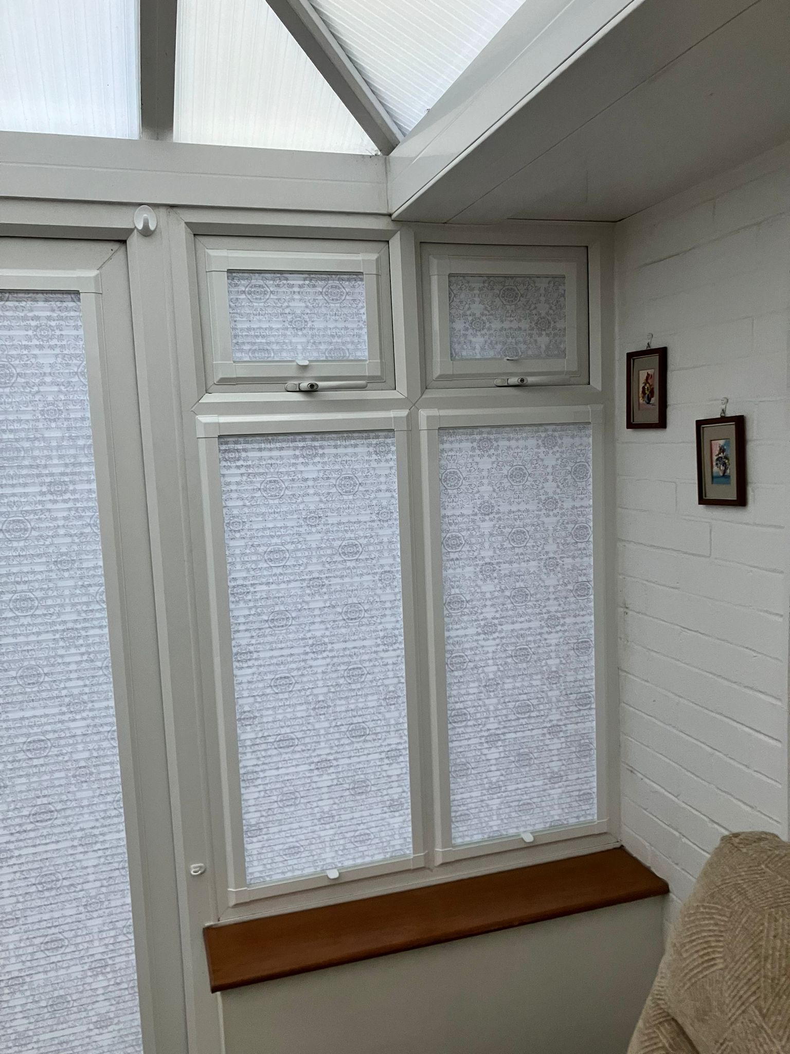 A living room with a couch and a window with blinds on it.