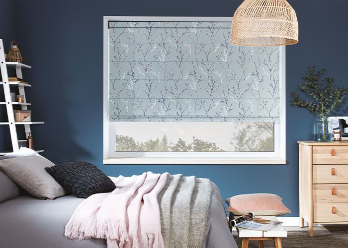 A bedroom with a bed , dresser , and window with a blue wall.