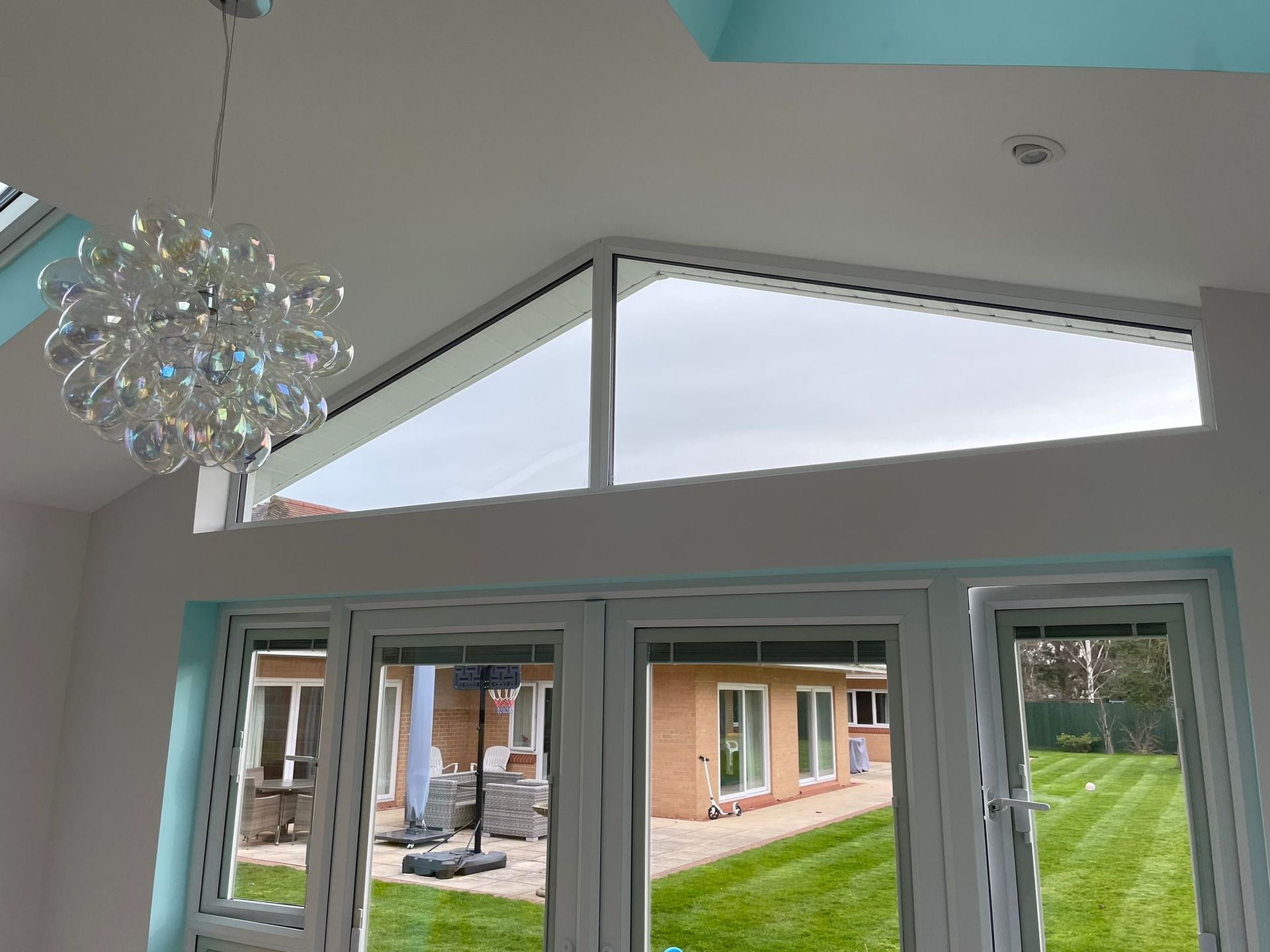 A room with a lot of windows and a chandelier hanging from the ceiling.