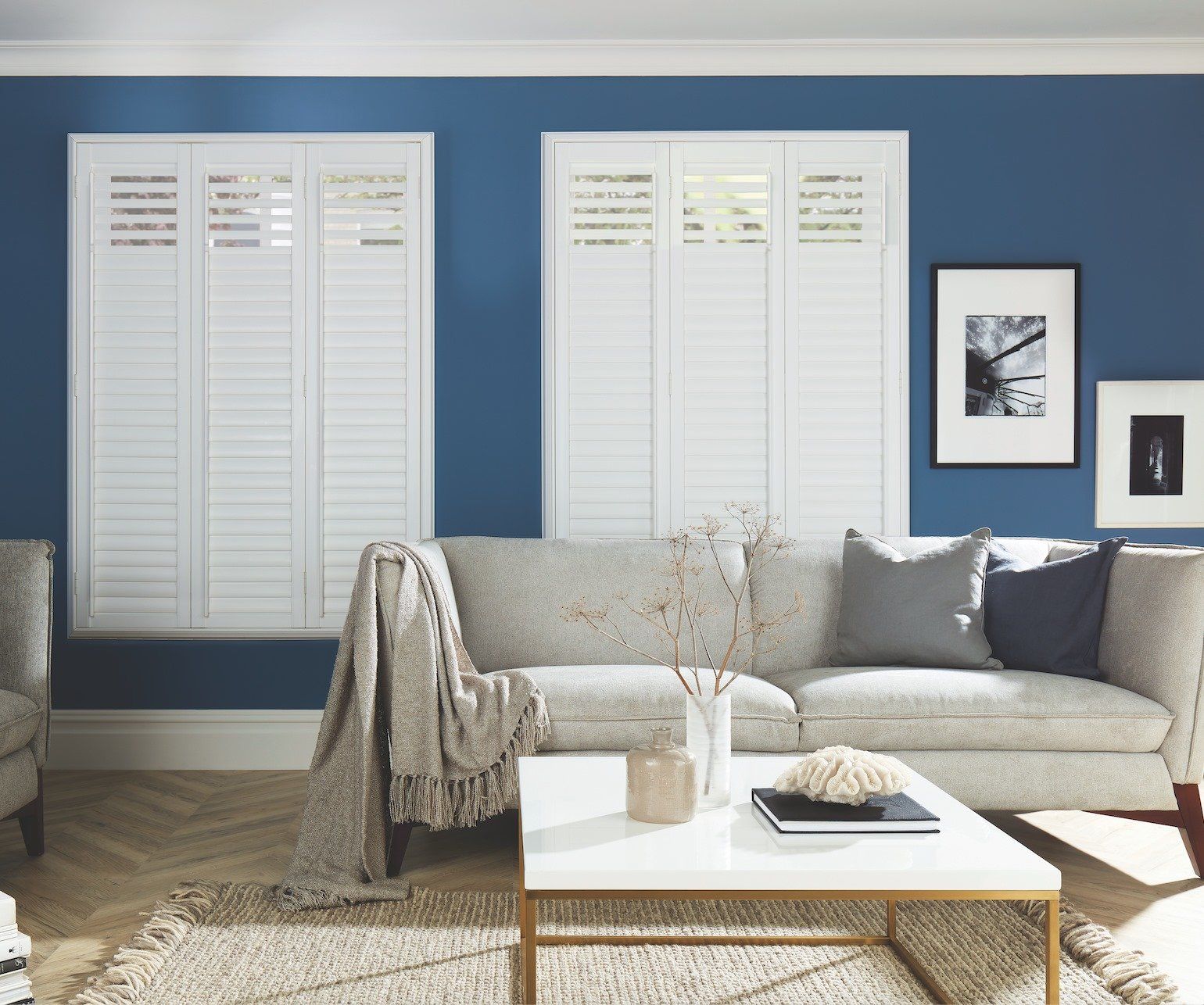 A living room with blue walls and white shutters