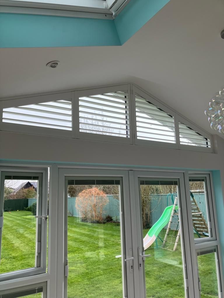 A room with a lot of windows and a slide in the backyard.