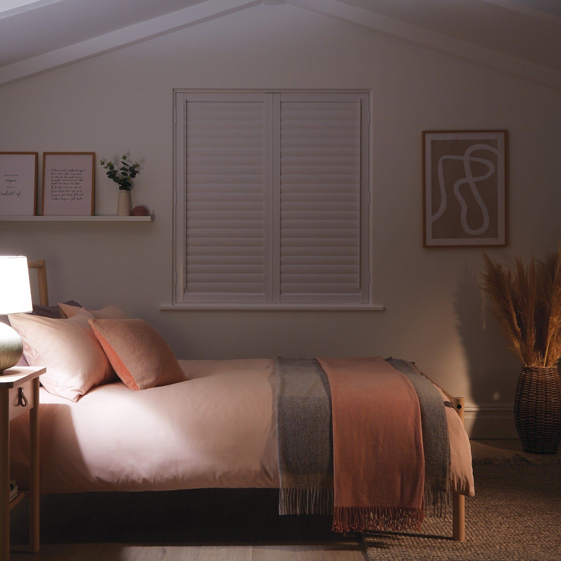 A bedroom with a bed and a window with shutters