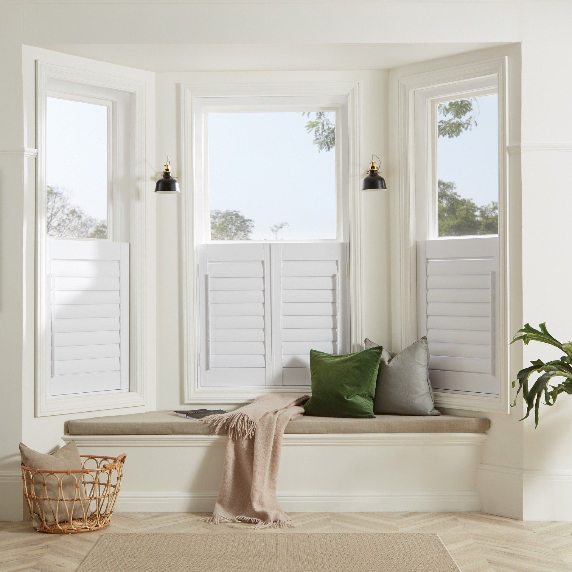 A window seat with shutters and pillows in a living room.