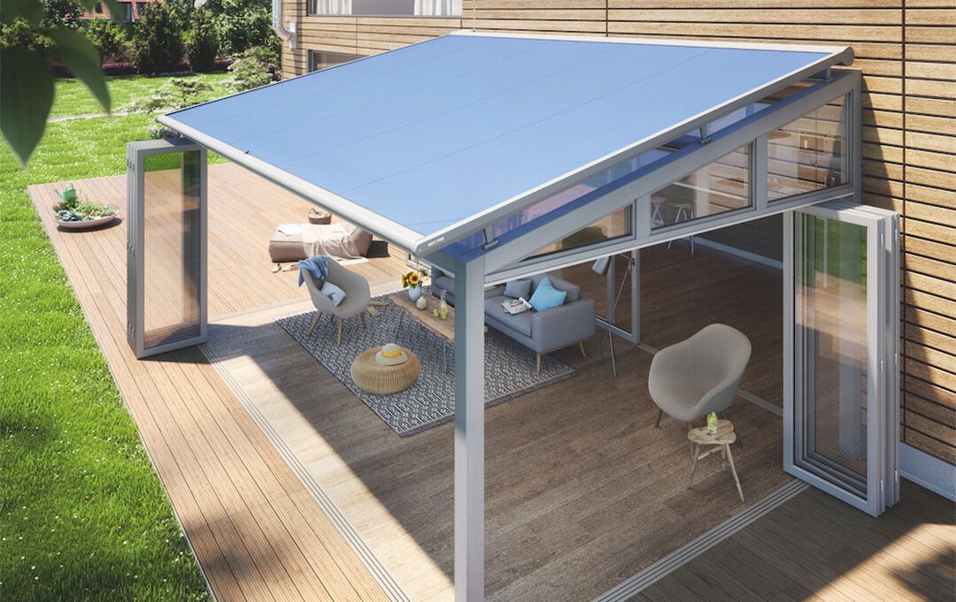 A patio with a blue awning and a couch and chairs on it.