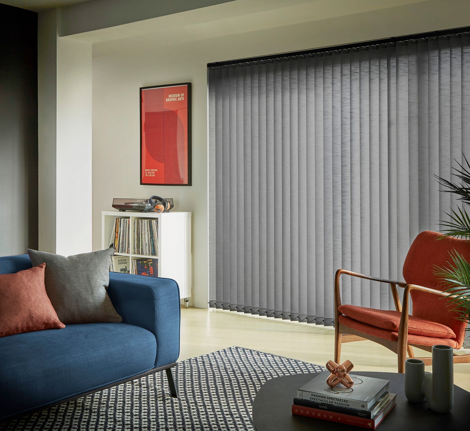 A living room with a blue couch and a red chair