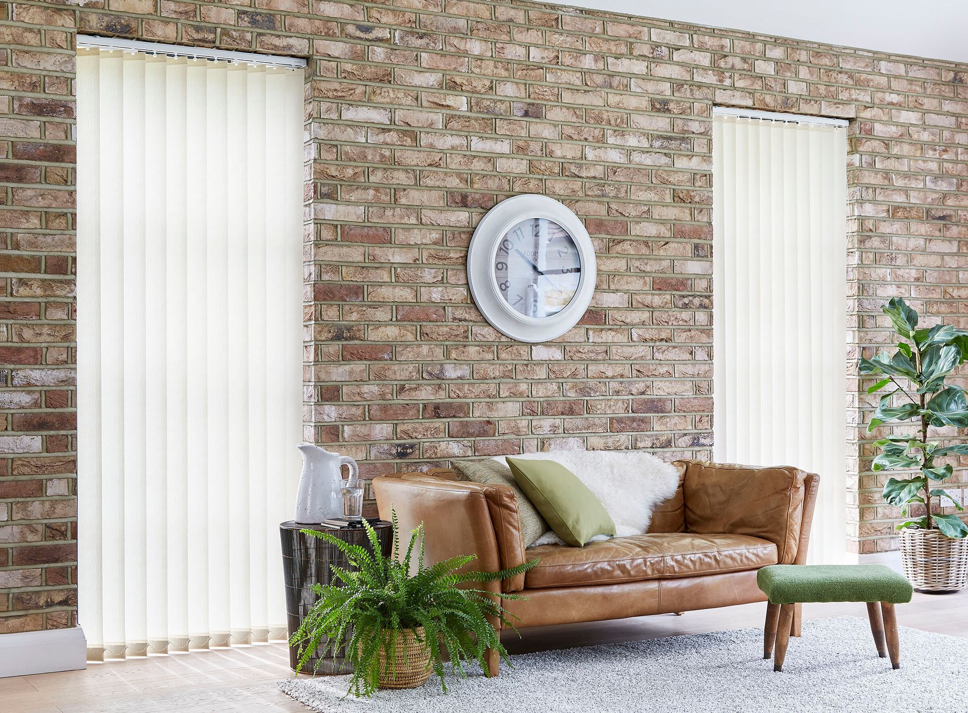 A living room with a couch and a clock on the wall.