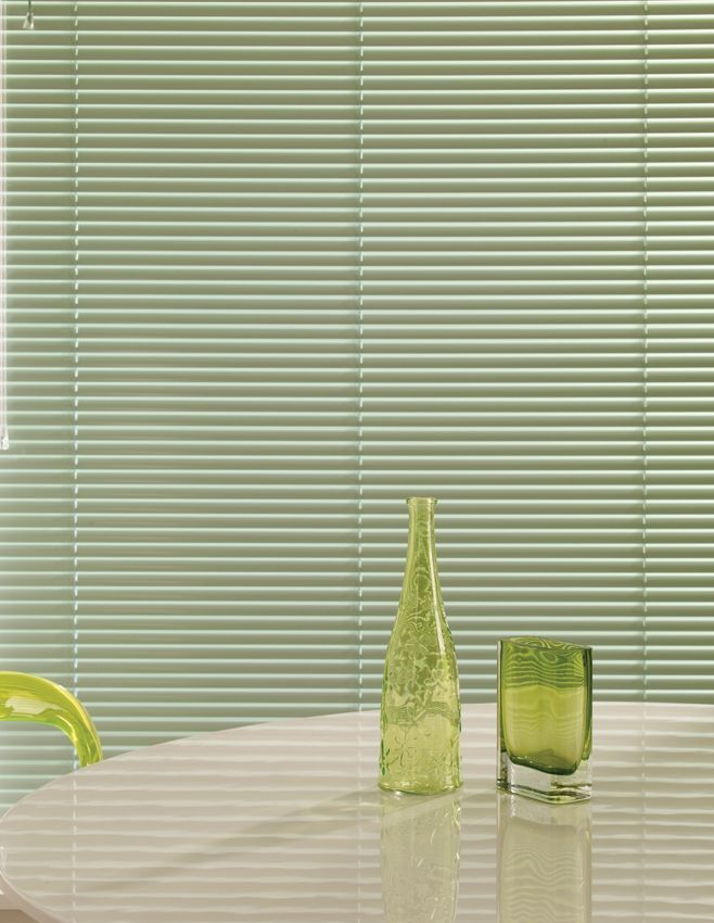 A table with a vase and a glass on it.